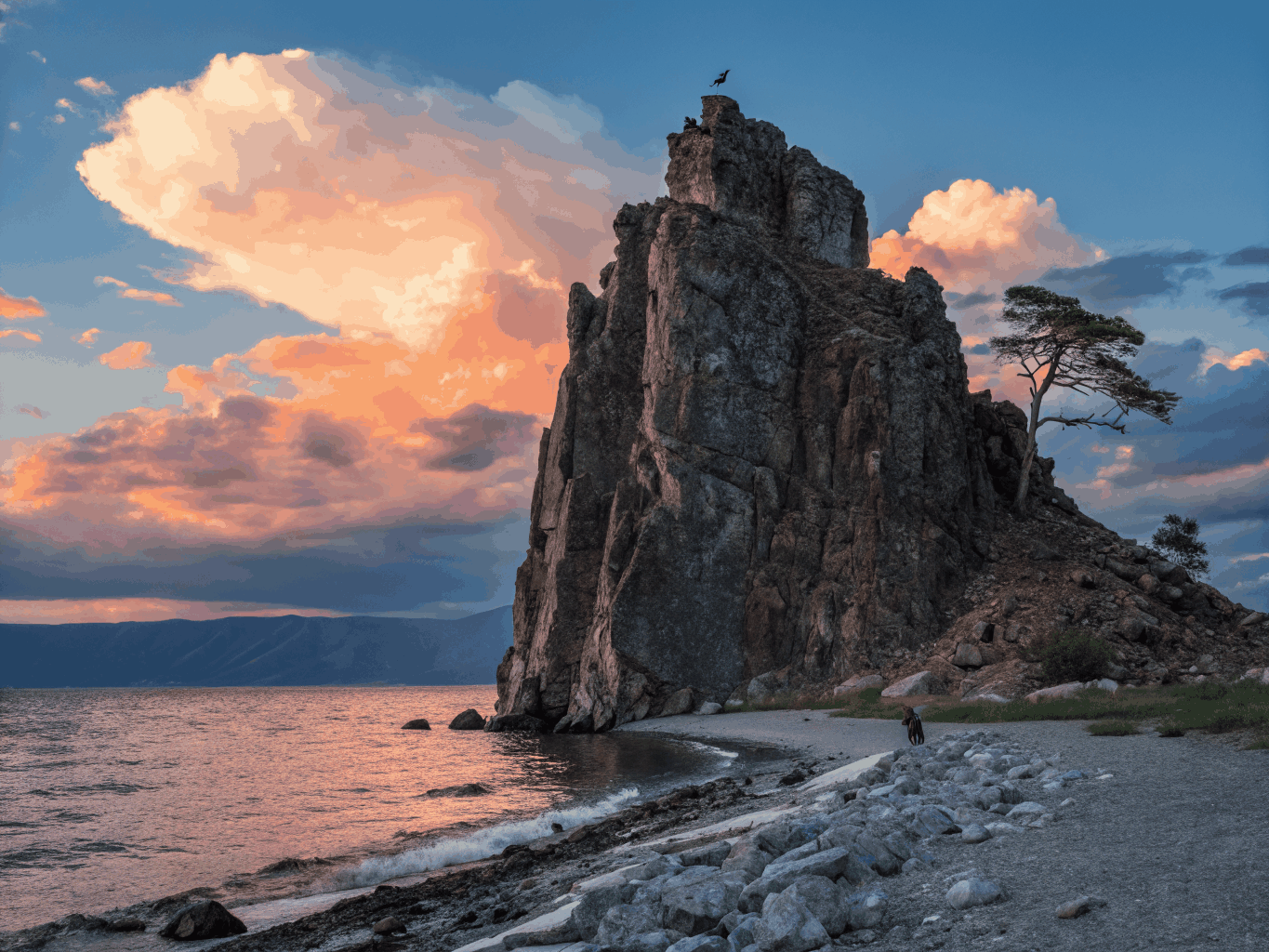 Ancient sacred cliff silhouette illuminated by fiery orange golden hour